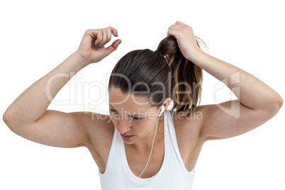 Athlete woman tying her hair and listening to music
