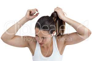 Athlete woman tying her hair and listening to music