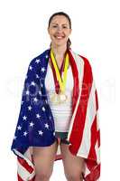 Athlete posing with american flag and gold medals around his nec