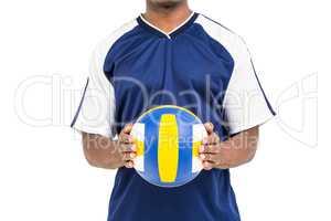 Mid-section of sportsman holding a volleyball