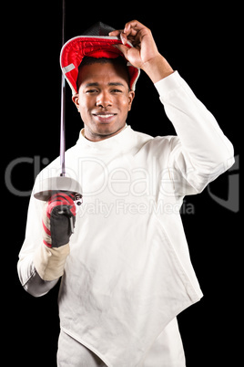 Portrait of swordsman standing with fencing mask and sword