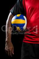 Mid-section of sportsman holding a volleyball