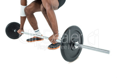 Mid-section of bodybuilder lifting heavy barbell weights