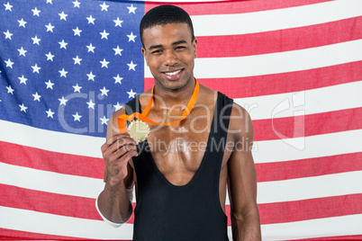 Athlete showing his gold medal in front of american flag