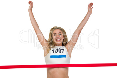 Portrait of cheerful winner athlete crossing finish line