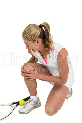 Injured athlete with tennis racket and tennis ball