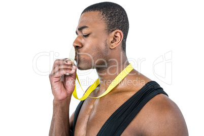 Happy athlete kissing medal