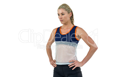 Female athlete standing with hand on hip