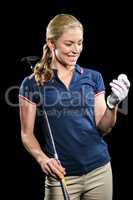 Golf player holding a golf club and golf ball