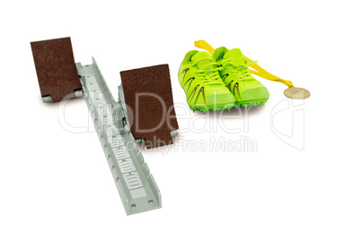 Trainer shoes, starting block and gold medal on white background