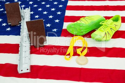 Trainer shoes, starting block and gold medal on american flag