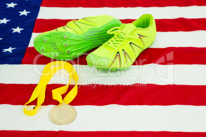 Trainer shoes and gold medal on american flag