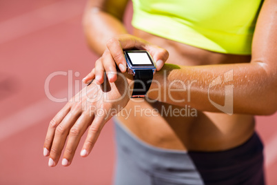Mid-section of female athlete checking her smart watch