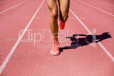 Female athlete running on the racing track