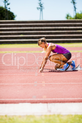 Female athlete ready to run on running track