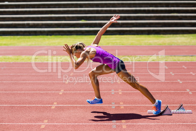 Female athlete running on the racing track