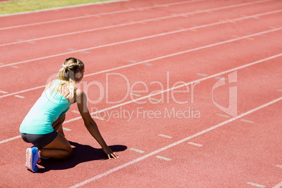 Female athlete ready to run on running track