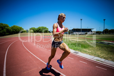 Female athlete running on the racing track