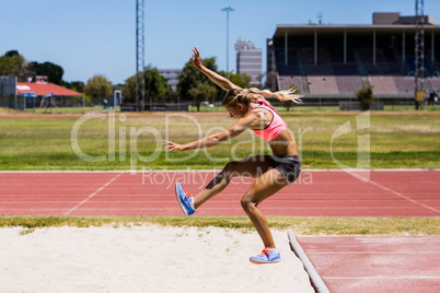 Female athlete performing a long jump