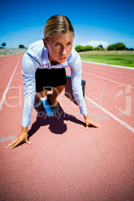 Businesswoman ready to run on running track