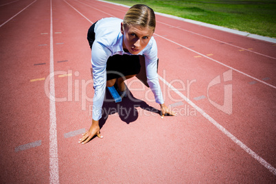 Portrait of businesswoman ready to run on running track