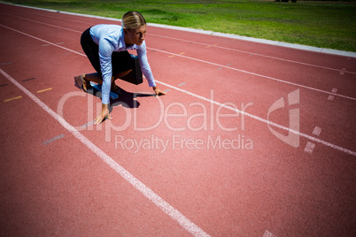 Businesswoman ready to run on running track