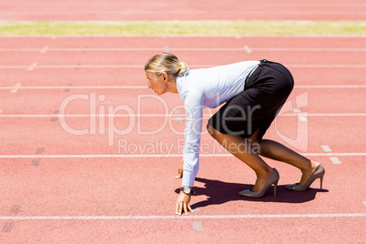 Businesswoman ready to run on running track