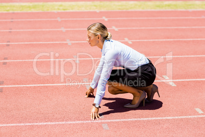 Businesswoman ready to run on running track