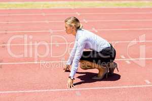 Businesswoman ready to run on running track