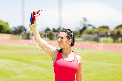 Happy female athlete showing her gold medals