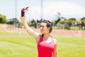 Happy female athlete showing her gold medals