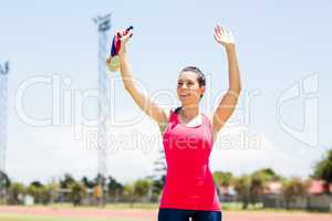 Female athlete waving her hand and showing gold medal
