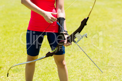 Mid-section of female athlete practicing archery