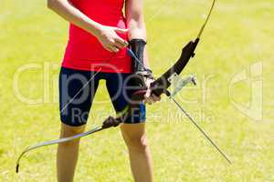 Mid-section of female athlete practicing archery