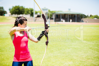 Female athlete practicing archery
