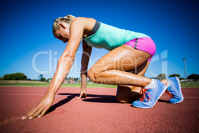 Female athlete ready to run on running track