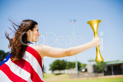 Female athlete wrapped in american flag holding fire torch