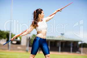 Female athlete carrying javelin on her shoulder