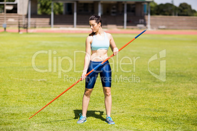 Female athlete holding a javelin in stadium