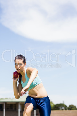 Female athlete preparing to throw shot put ball