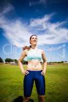 Confident female athlete standing with hand on hip