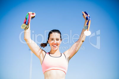 Happy female athlete showing her gold medals