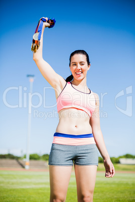 Happy female athlete showing her gold medals