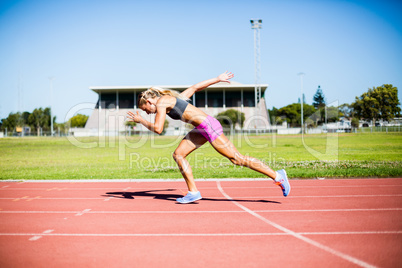 Female athlete running on the racing track