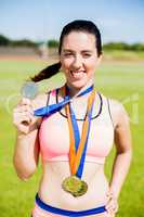 Portrait of female athlete showing her gold medals