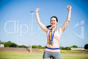 Excited female athlete with gold medals around her neck