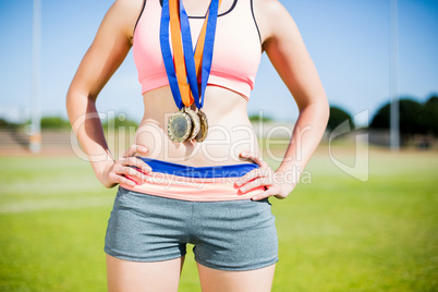 Mid section of female athlete with gold medals around her neck