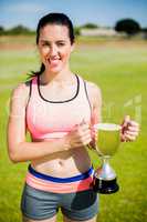 Happy female athlete holding a trophy