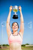 Happy female athlete showing her trophy