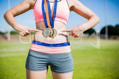 Mid section of female athlete with gold medals around her neck